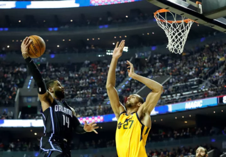 El jugador de Orlando Magic D.J. Augustín (izq.) conduce el balón a la canasta ante Rudy Gobert, de Utah Jazz. /Foto EFE