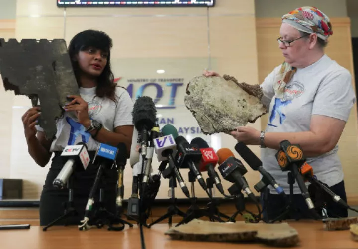 Grace Subathirai Nathan (i), hija de una víctima del vuelo MH370 de Malaysia Airlines, y Jacquita Gonzales, cuyo marido era un miembro de la tripulación, muestran dos piezas que podrían pertenecer al avión que desapareció. EFE