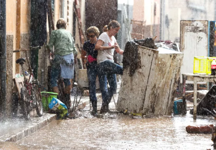 Los residentes colocan sus pertenencias dañadas en la calle bajo una lluvia torrencial, en Sant Llorenc, España. AP