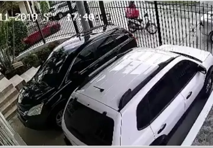 La cámara de seguridad de una residencia captó cuando dos sujetos le roban a un motorizado de comida rápida en Brisas del Golf.