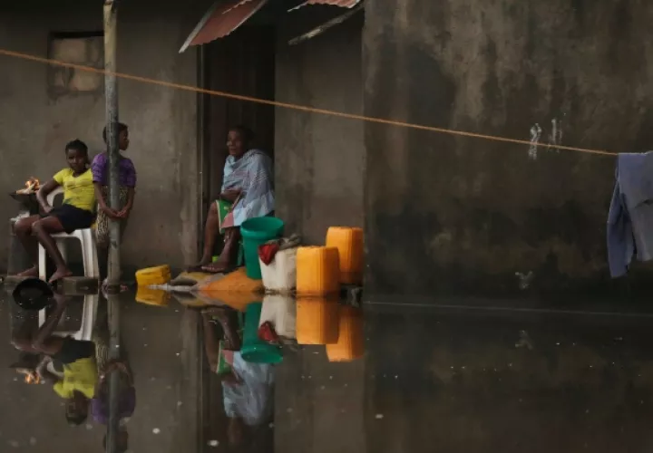 Un grupo de personas esperan que el nivel de las aguas bajen para recibir ayuda al perder todo por causa del cicló Idai. FOTO/AP 