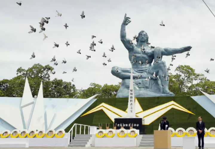 Palomas vuelan sobre la Estatua de la Paz durante la ceremonia en Nagasaki. Foto: AP.