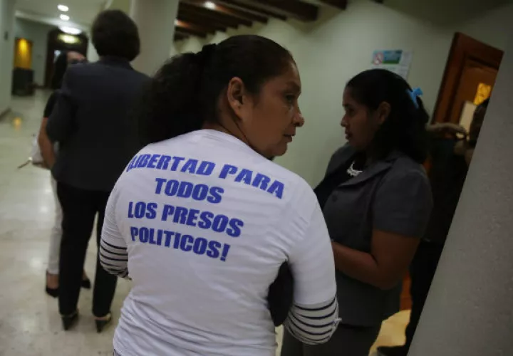  Una opositora luce una camiseta dedicada a los "presos políticos" tras una reunión de la OEA en El Salvador. Foto: EFE.