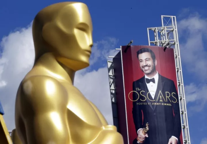 Detalle de estatua de Óscar con el fondo de una imagen del presentador Jimmy Kimmel.  EFE
