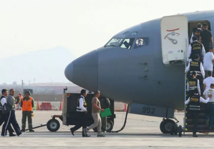 Policías escoltan a venezolanos en una base militar del Callao, donde fueron deportados por dar información personal falsa. Foto: AP.  