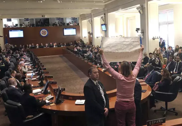 La activista Medea Benjamín con el grupo Code Pink, interrumpe los comentarios del secretario de Estado Mike Pompeo durante una sesión extraordinaria sobre la crisis en Venezuela celebrada por la Organización de los Estados Americanos,. FOTO/AP