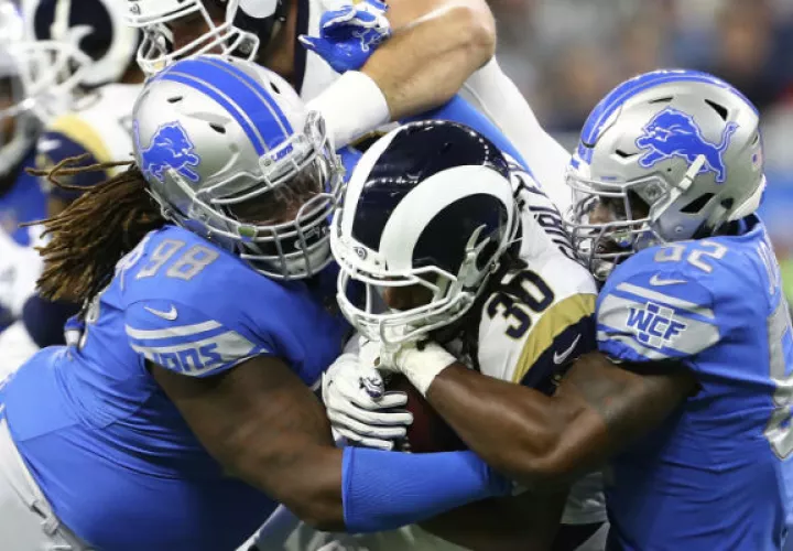 Todd Gurley (30) de los Rams es bloqueado por dos jugadores de Detroit Lions. Foto:AP