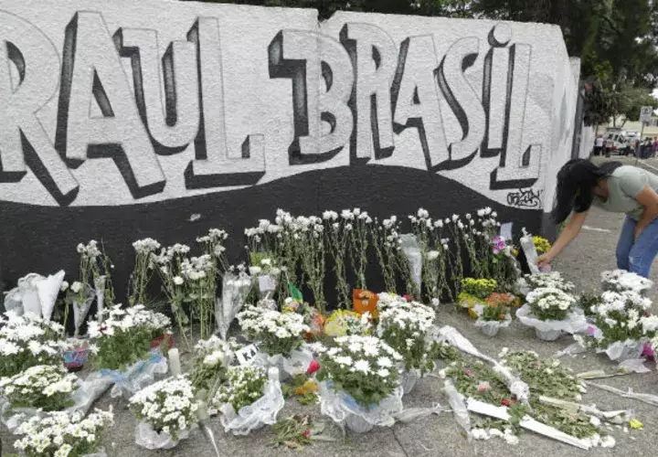 Una mujer coloca flores como tributo a las víctimas de la matanza en Suzano, Brasil. Foto: AP. 