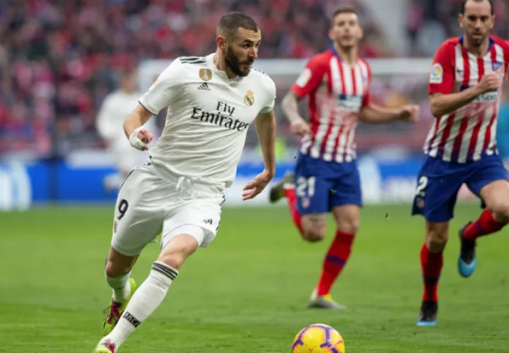  El delantero francés del Real Madrid Karim Benzema (Izq.) controla el balón ante rivales del Atlético de Madrid. Foto:EFE
