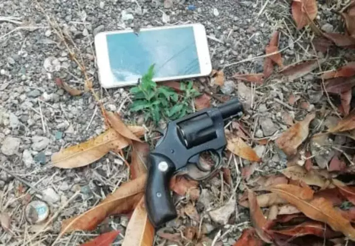 Revólver y un celular que fue arrojado fuera del penal. Foto: Eric A. Montenegro.