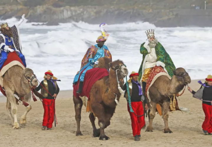 Los Reyes Magos a su llegada en camello a una playa del norte de España./ Fotos: EFE