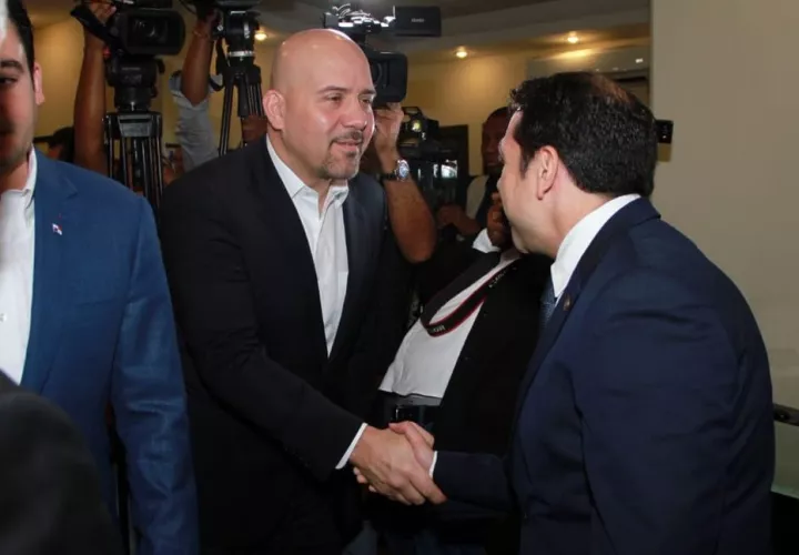 Rolando Mirones (izq.) saluda al ministro de Seguridad Pública, Jonattan Del Rosario, antes de iniciar la reunión de transición en este ministerio. 