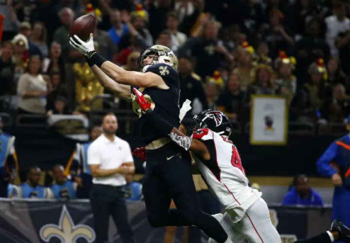 Dan Arnold de Saitns (85) atrapa el balón ante el salto del defensa de los Falcons,  Sharrod Neasman. Foto:AP