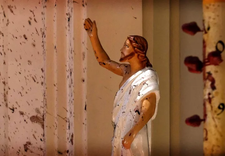 Manchas de sangre se ven en la pared y en una estatua de Jesucristo en la Iglesia de San Sebastián después de la explosión en Sri Lanka, hoy, domingo 21 de abril. Foto AP