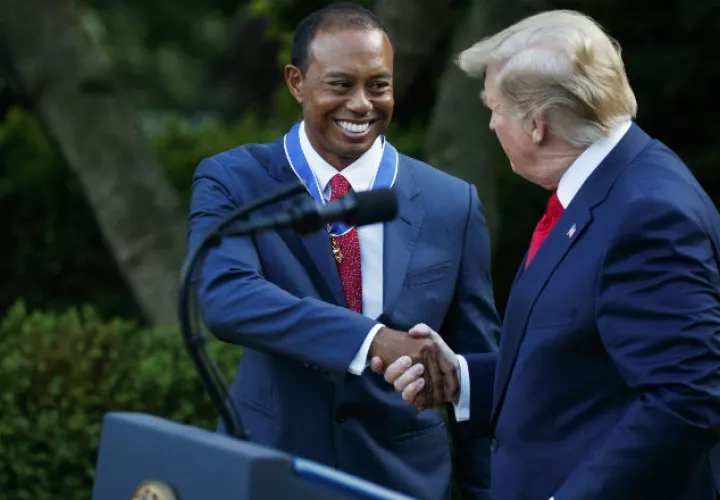 El presidente de Estados Undos Donald Trump  (der.) le da la mano al golfista Tiger Woods, luego de otorgarle la Medalla Presidencial de la Libertad. Foto:AP