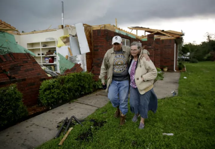Una madre y su hijo tras su vivienda destruida por la tormenta. Foto: AP. 