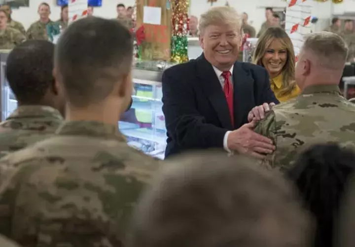 Donald Trump y su esposa la primera dama Melania Trump, junto a los saldados acantonados en Irak. FOTO/AP