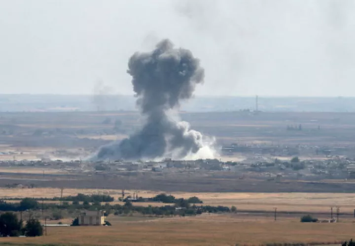 Jóvenes con la bandera turca al paso de blindados militares turcos en el noreste de Siria. Foto: EFE.