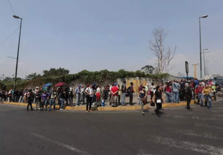 Los ciudadanos en Caracas  hacen largas filas esperando un bus. FOTO/EFE 