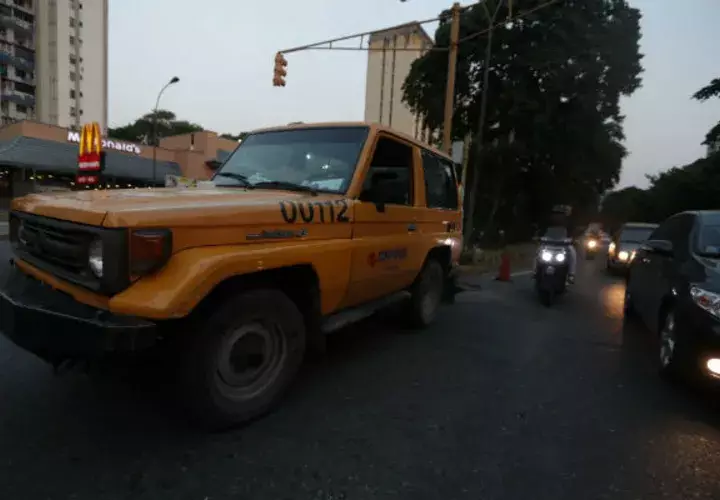 Vehículos transitan por una calle sin alumbrado público por la falta de fluido eléctrico en Caracas (Venezuela). Foto: EFE.