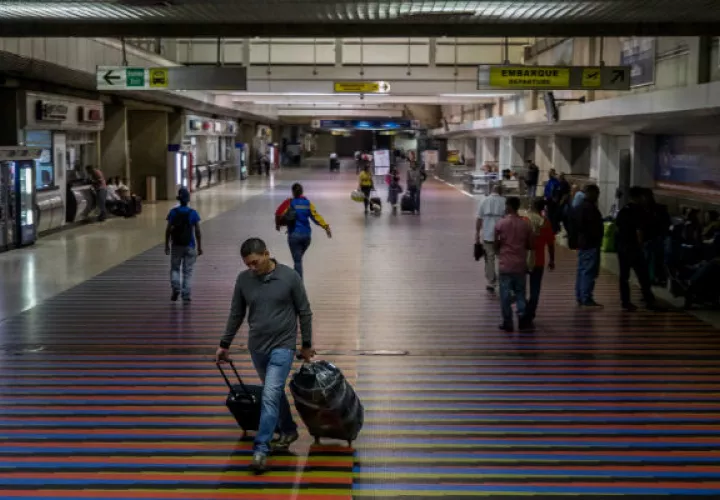 Foto archivo que muestra a algunos viajeros en el aeropuerto internacional Simón Bolívar, en Maiquetía (Venezuela).  Foto: EFE.
