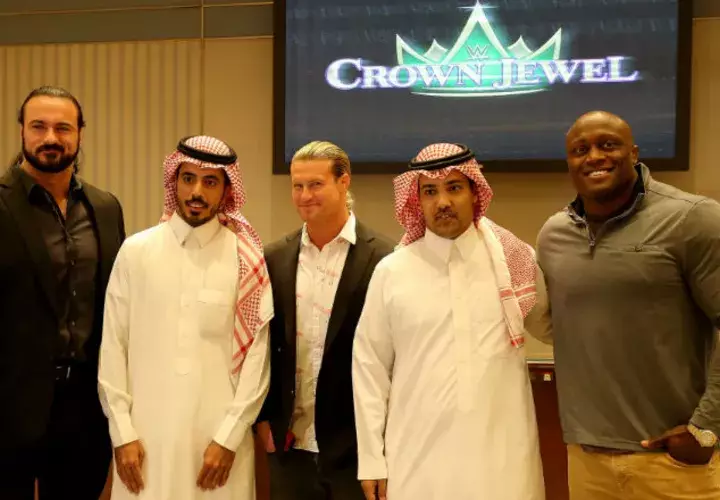 Los luchadores Drew McIntyre (i), Dolph Ziggler (2i), y Bobby Lashley (d) posan con aficionados en Arabia Saudi. Foto EFE