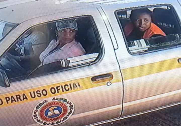 Imagen de la funcionarias vistas tomando fotos fuera de la residencia de Yanibel Ábrego.