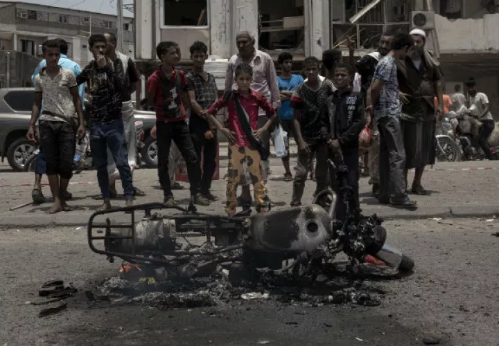Civiles observan una moto destruida en Aden. Foto: AP