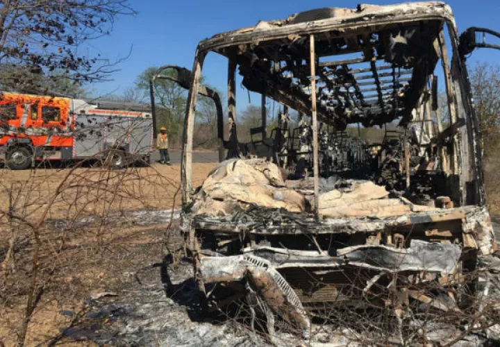 Un camión de bomberos se mantiene estacionado cerca del autobús quemado en Zimbabue. AP