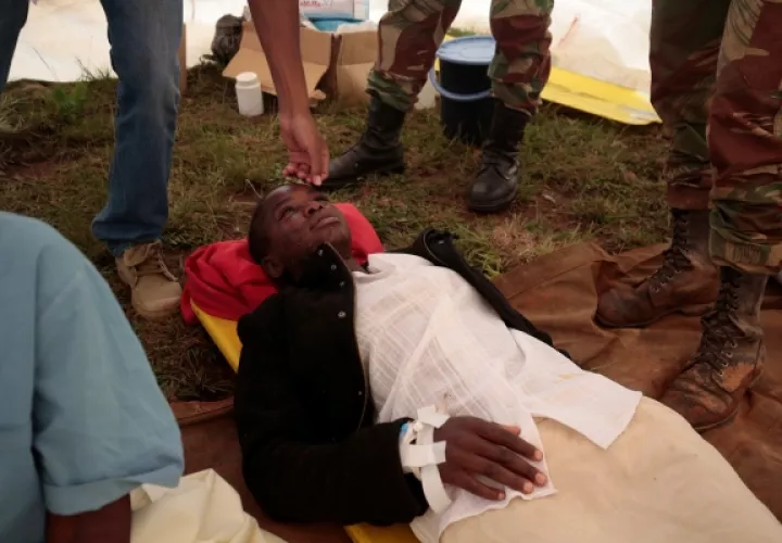 Miembros del Ejército Nacional de Zimbabwe observan a una mujer rescatada a las afueras de Chimanimani, a unos 500 km al este de la capital, Harare (Zimbabue). FOTO/EFE